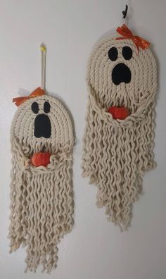 two woven wall hangings made to look like bears with long hair and beards