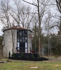 a small round building sitting in the middle of a forest