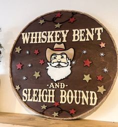 a wooden sign that says whiskey bent and sleigh bound with a santa clause on it