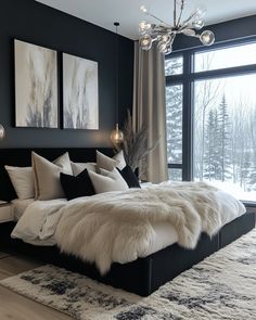 a large bed with white fur on it in a bedroom next to a big window