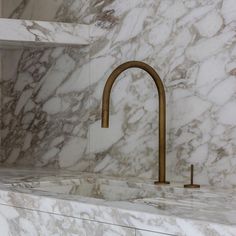 a kitchen with marble counter tops and brass faucets