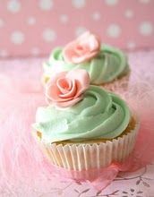 two cupcakes with green frosting and pink roses