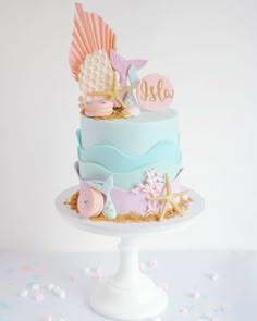 a three tiered cake with pink and blue decorations