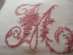 an embroidered piece of cloth with pink thread