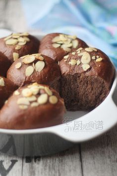 there are some chocolate muffins with nuts in the middle on a white plate