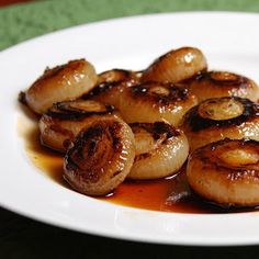 some food is sitting on a white plate with sauce in front of it and green table cloth