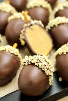 chocolate covered candies with nuts and peanut butter in the middle on a wooden table