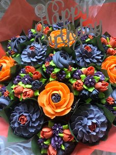 an orange and blue bouquet with happy new year written in it's center surrounded by other flowers