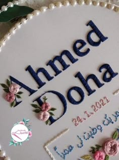 a birthday cake with flowers on it and the words amed doha written in blue