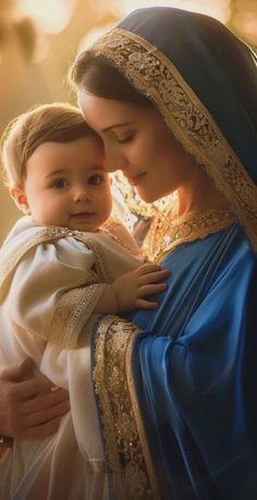 a woman holding a baby wearing a blue and white dress with gold trimmings