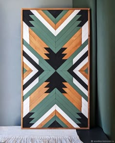 a wooden wall hanging in the corner of a room with green walls and wood flooring