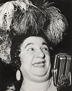 an old black and white photo of a woman holding a microphone in front of her face