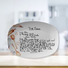 a dish with writing on it sitting on a counter top next to a wooden table