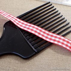 a black comb with a red and white checkered ribbon