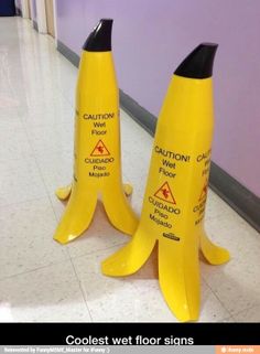 two yellow caution cones sitting next to each other on the floor in front of a purple wall