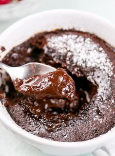 a spoon full of chocolate pudding with powdered sugar