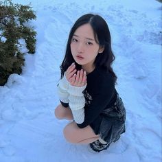 a woman kneeling in the snow with her hands together