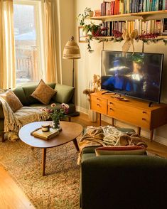 a living room filled with furniture and a flat screen tv on top of a wooden table