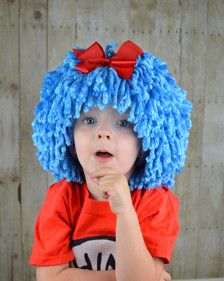 a young child wearing a blue wig and eating