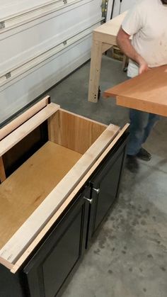 a man is working on some cabinets in a room with other workbench materials