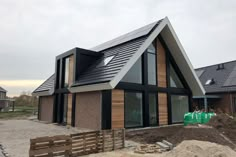 a house that is being built in the middle of some dirt and grass with windows on each side