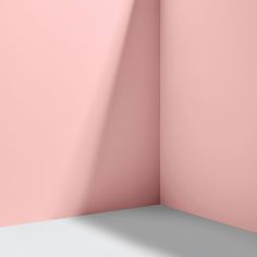 the corner of a room with a pink wall and a white floor in front of it