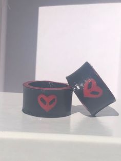 two black and red bracelets with hearts on them