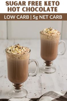 two glasses filled with hot chocolate and topped with whipped cream