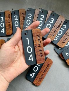 a person holding up some wooden tags with numbers on them