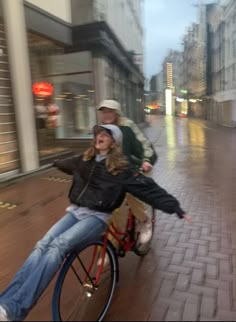 a man riding on the back of a bike next to a woman in black jacket