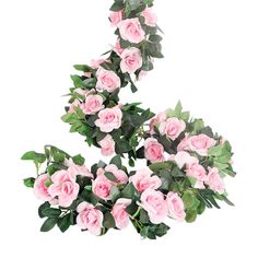 pink roses are arranged in the shape of an oar with green leaves on each side