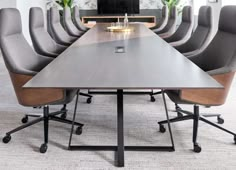 a long table with chairs around it and a television in the back ground behind it