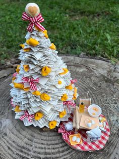 a small christmas tree made out of dollar bills on top of a wooden stump in the grass