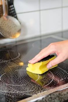 someone is cleaning the stove with a sponge