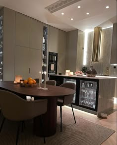 a dining room table and chairs with candles on it in front of a kitchen counter