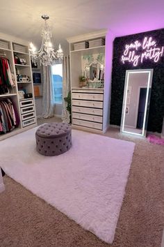 a bedroom with white carpet, chandelier and purple lighting