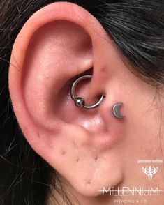 a close up of a person's ear with two piercings on it,