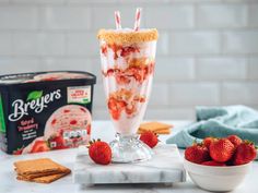 strawberries and ice cream in a glass on a marble table next to two boxes of brier's