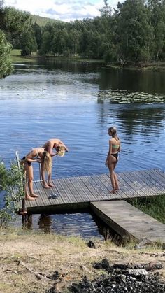 two women in bathing suits standing on a dock