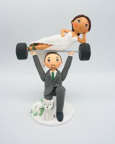 a wedding cake topper with a bride and groom on the back of a car