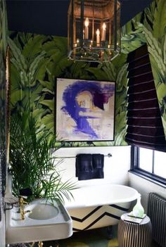 a bathroom with a tub, sink and painting on the wall above it's windows