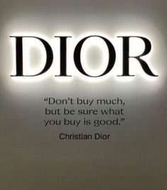 the words dior are lit up in front of a white wall with black lettering