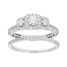 an engagement ring and wedding band set in white gold with round brilliant cut diamonds on each side