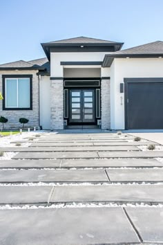 an image of a house with snow on the ground and two garages in front