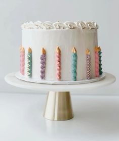 a white cake with colorful candles on it