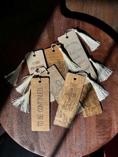 wooden tags with words and tassels on them sitting on a table next to a chair