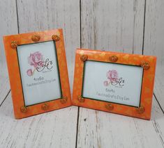 two orange frames with flowers on them sitting next to each other