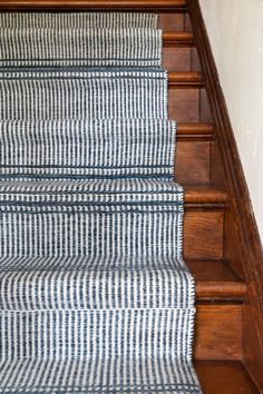 blue and white striped stair runner on wooden stairs