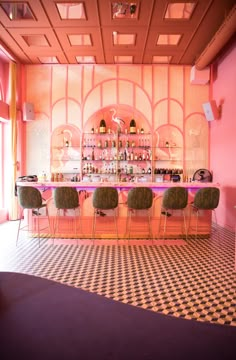 the bar is decorated with pink walls and black and white checkered flooring