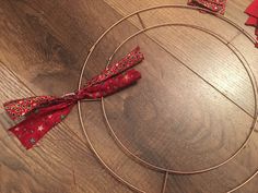 a red bow is tied to a wire wreath on the floor with other decorations around it